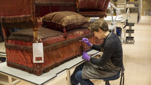 Senior conservator, Heather Porter, working on the iconic Knole Sofa in the Conservation Studio at Knole, Kent